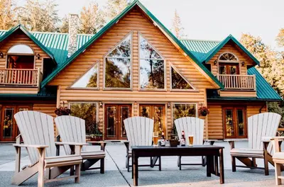 a cabin with a table and chairs in front of it at Cowichan River Lodge in Lake Cowichan