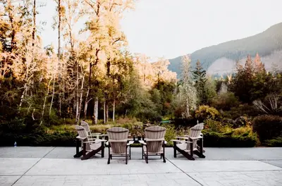 a patio with chairs and a table with a view at Cowichan River Lodge in Lake Cowichan