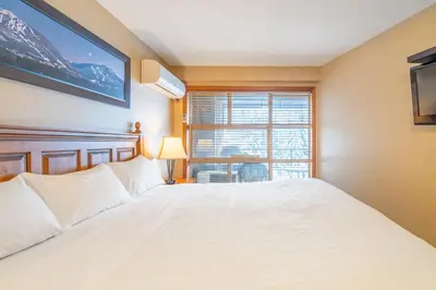 a bedroom with a white bed and a window at #433 The Aspens On Blackcomb in Whistler