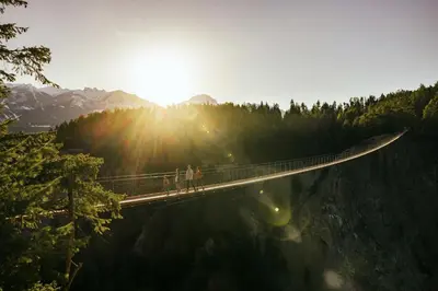 two people on a suspension bridge over a lake at Best Western Mountainview Inn in Golden