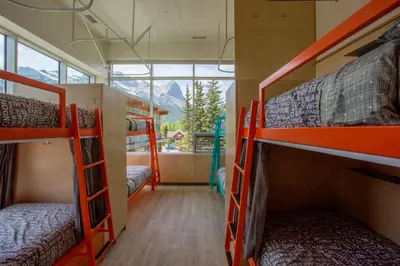 a room with four bunk beds and a window at Canmore Downtown Hostel in Canmore