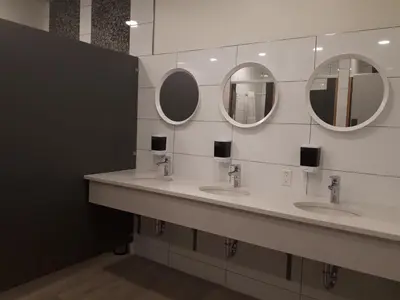 a bathroom with three sinks and three mirrors at Canmore Downtown Hostel in Canmore