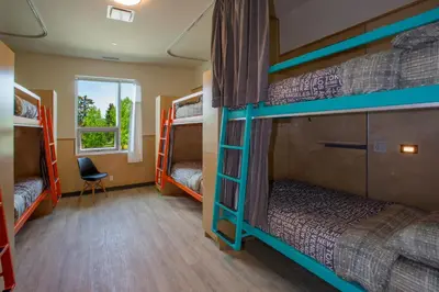 a room with four bunk beds and a window at Canmore Downtown Hostel in Canmore