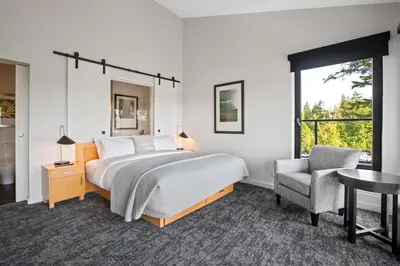 a bedroom with a bed and a desk and a chair at Black Rock Oceanfront Resort in Ucluelet