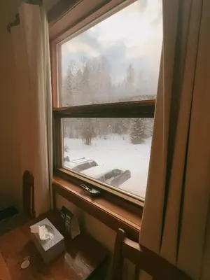 a window with a view of a snow covered yard at Alpine Meadows Lodge in Golden