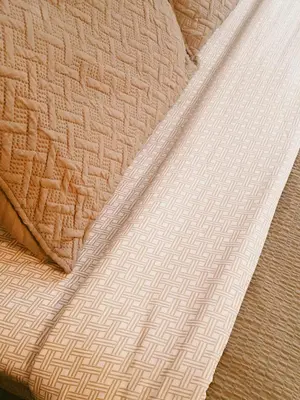 a close up of a bed with a tan and white blanket at Alpine Meadows Lodge in Golden