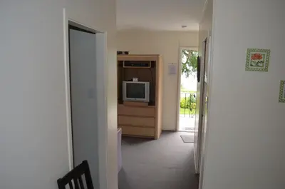 a hallway with a tv and a door to a room at Seaside Villa Motel & RV Park in Powell River