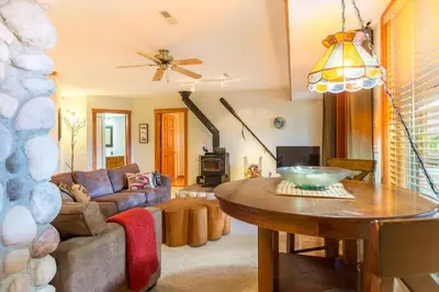 a living room with a table and a couch at Tranquility Bay Waterfront Inn in Sechelt