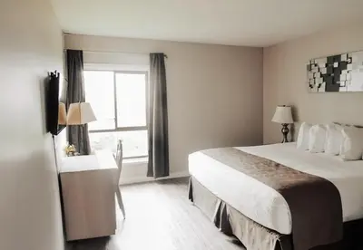 a hotel room with a bed and a window at Sechelt inn in Sechelt