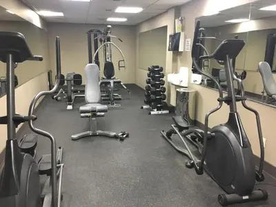 a gym with several treadmills and exercise bikes at Heavenly Mountain Condo managed by Little Sister Getaways in Canmore