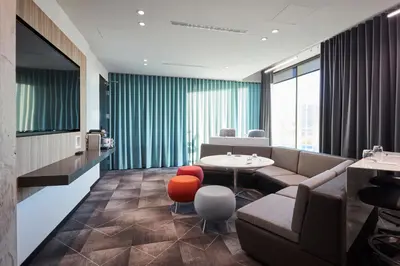 a living room with a couch and a table and chairs at Alt Hotel Calgary East Village in Calgary