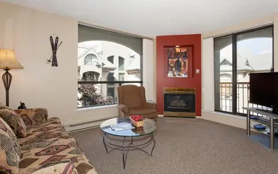 a living room with a couch and a table and a tv at The Marquise by Whistler Premier in Whistler