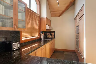 a kitchen with wooden cabinets and a black counter top at Montebello by Whistler Premier in Whistler