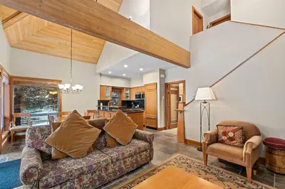 a living room with a couch and a kitchen at Montebello by Whistler Premier in Whistler