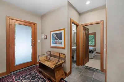a room with a wooden bench in a room with a bedroom at Montebello by Whistler Premier in Whistler