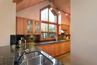 a large kitchen with wooden cabinets and a sink at Montebello by Whistler Premier in Whistler