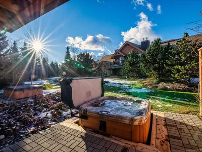 a hot tub sitting on a patio next to a river at Montebello by Whistler Premier in Whistler