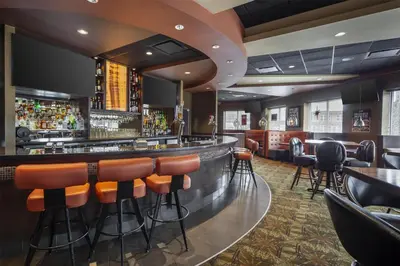a bar in a restaurant with orange stools at Best Western Cold Lake Inn in Cold Lake