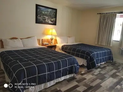 a hotel room with two beds and a window at Pleasant Valley Motel Houston in Houston