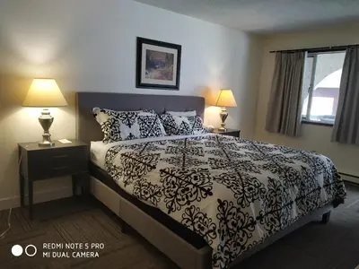 a bedroom with a black and white bed with two lamps at Pleasant Valley Motel Houston in Houston
