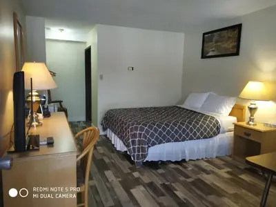 a hotel room with a bed and a desk at Pleasant Valley Motel Houston in Houston