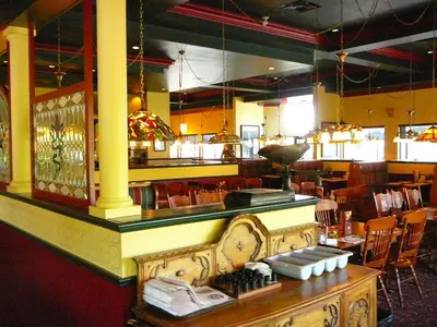 a restaurant with a counter and a bar with chairs at Coast Abbotsford Hotel & Suites in Abbotsford