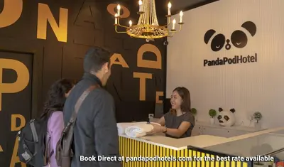 a group of people standing around a table in a store at Panda Pod Hotel in Richmond
