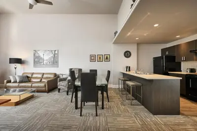 a kitchen and living room with a table and a couch at SoLo Suites in Victoria