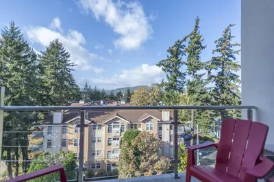 a balcony with two chairs and a large building at SoLo Suites in Victoria