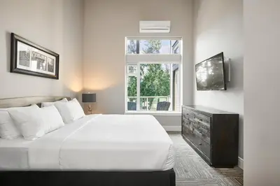 a bedroom with a white bed and a window at SoLo Suites in Victoria