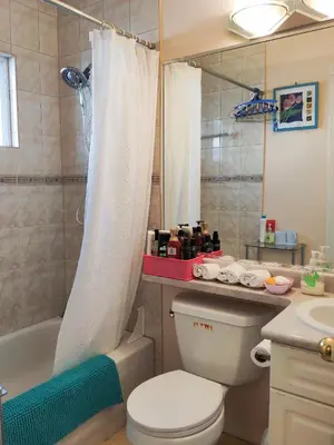 a bathroom with a toilet and a tub and a sink at Helen's House / Close to Skytrain and Airport in Vancouver