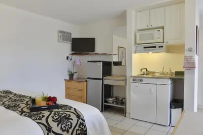 a room with a kitchen with a bed and a microwave at Valley Star Motel in Penticton