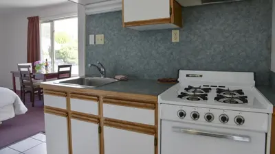 a kitchen with a white stove and a sink at Valley Star Motel in Penticton