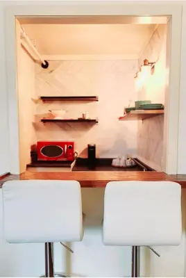 two white chairs in a kitchen with a counter at Western Lodge in Kimberley
