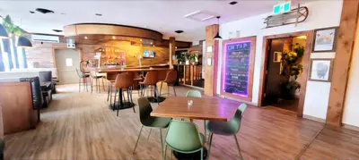 a restaurant with a bar with tables and chairs at Western Lodge in Kimberley