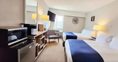 a hotel room with two beds and a flat screen tv at Western Lodge in Kimberley