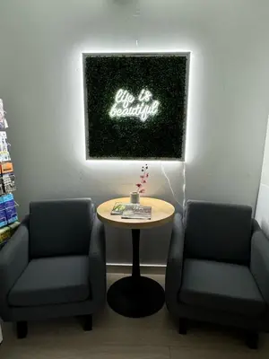 a waiting room with two chairs and a table and a sign at Inntowne Motel in Hope
