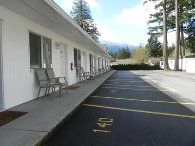 a building with chairs on the side of a road at Skagit Motel in Hope