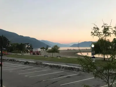 a parking lot with a view of the water and mountains at Spring Villa Hotel in Harrison Hot Springs