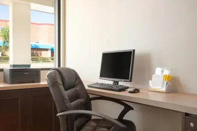 a computer sitting on a desk with a chair at Days Inn by Wyndham Calgary Northwest in Calgary