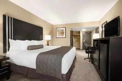 a hotel room with a large bed and a flat screen tv at Days Inn by Wyndham Calgary Northwest in Calgary