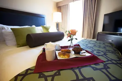 a tray of food on a bed in a hotel room at Executive Suites Hotel and Resort, Squamish in Squamish