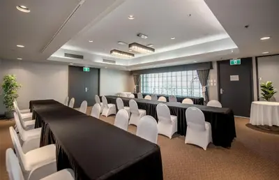 a conference room with black tables and white chairs at Coast Lonsdale Quay Hotel in North Vancouver