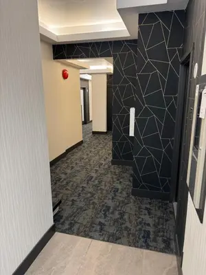 a hallway of an office with a black tile wall at Waterways, A Boutique Hotel in Powell River