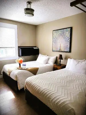 a hotel room with two beds and a window at Royal Duke Hotel in Okotoks