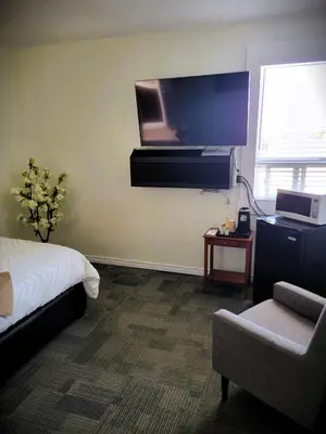 a bedroom with a bed and a flat screen tv at Royal Duke Hotel in Okotoks