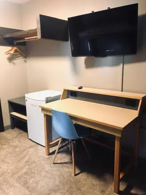 an office desk with a monitor and a blue chair at Banff International Hostel in Banff