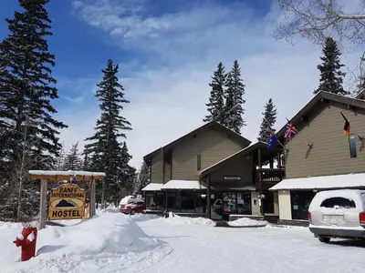 a ski lodge with a sign in the snow at Banff International Hostel in Banff