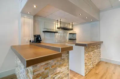 a kitchen with a bar with a brick wall at Bayside Resort, an Ascend Collection Resort in Parksville