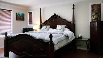 a bedroom with a large wooden bed with white pillows at Royalty B&B in Richmond